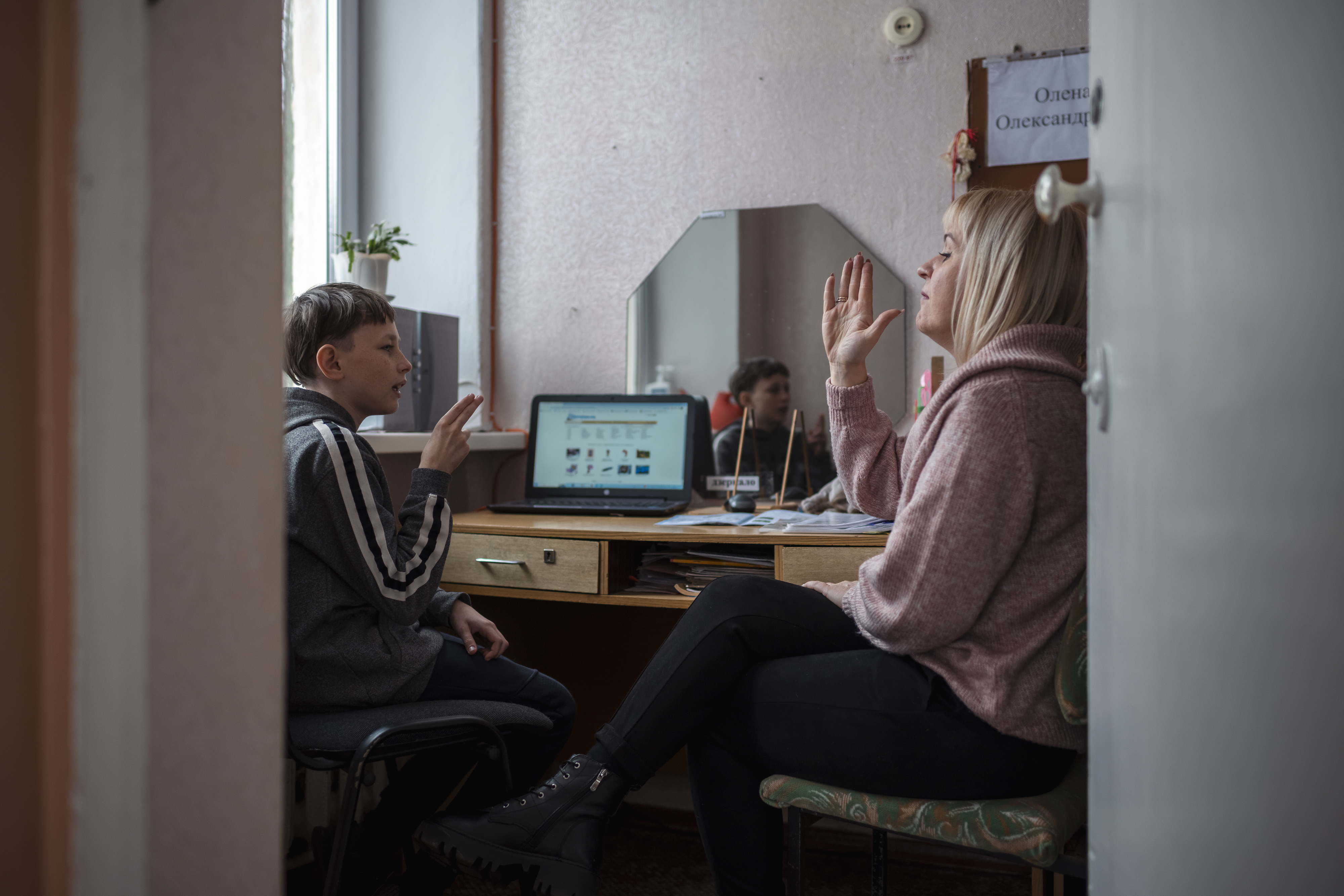 Ukrainalaisen erityisen tuen koulun oppilas opettelee tuntemaan ääniä opettajansa kanssa.